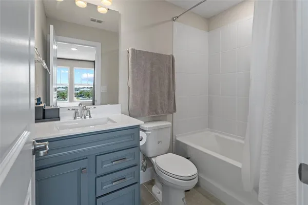 a bathroom with a granite countertop sink a toilet and shower