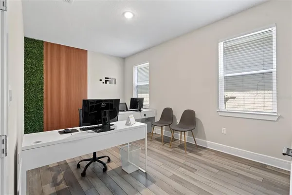 a work room with furniture a rug and a window