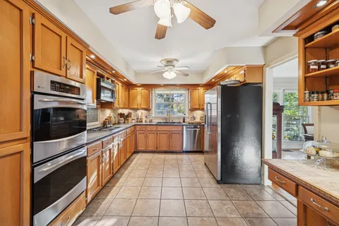 a kitchen with stainless steel appliances granite countertop a refrigerator a stove and a sink with cabinets