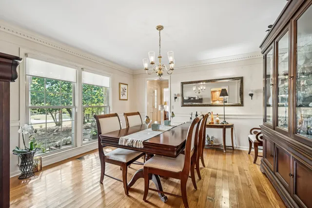 a dining room with furniture a chandelier and wooden floor