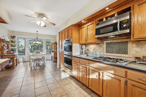 a kitchen with stainless steel appliances a stove a sink and cabinets