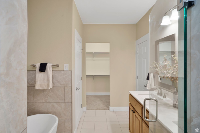 1570 South Rio Virgin Drive Washington, UT 84780 - Photo 36 of 71 Full bathroom with vanity, light tile patterned floors, a spacious closet, tile walls, and a freestanding bath
