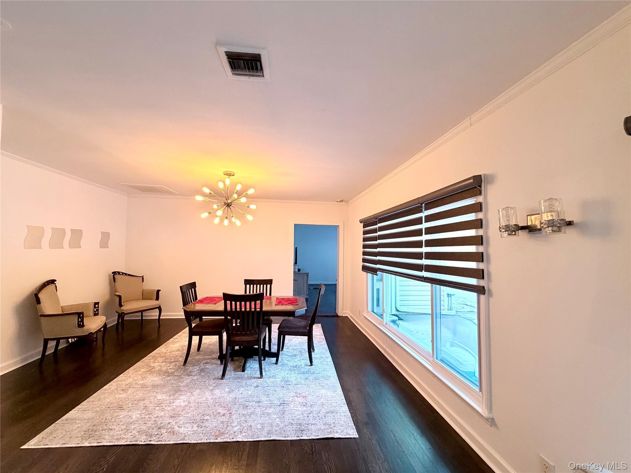 262 Channon Road Hewlett, NY 11557 - Photo 16 of 27 a dining room with furniture and a chandelier