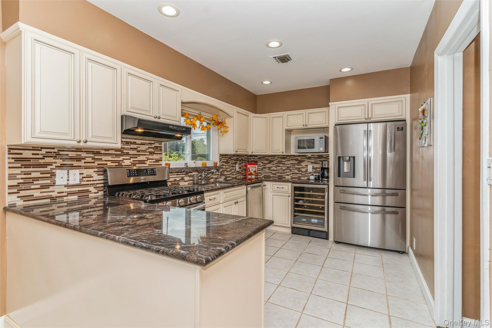 262 Channon Road Hewlett, NY 11557 - Photo 19 of 27 a kitchen with kitchen island a counter top space cabinets and stainless steel appliances