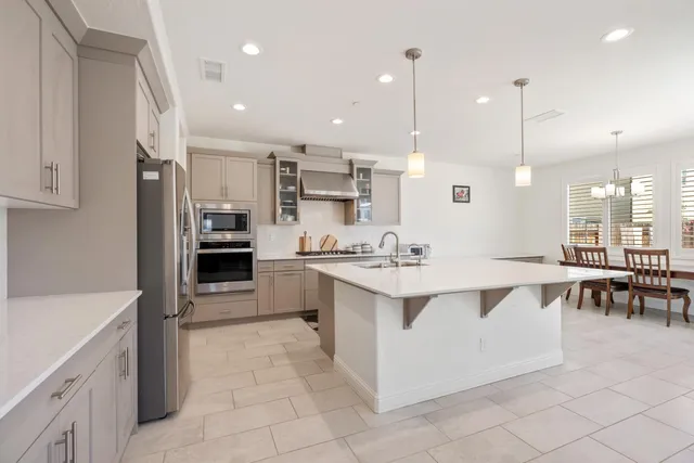 a large white kitchen with a large counter top kitchen appliances and a sink