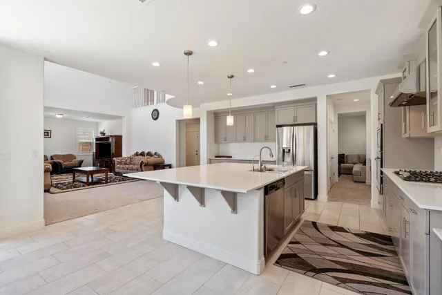 a large white kitchen with a large counter top appliances and cabinets