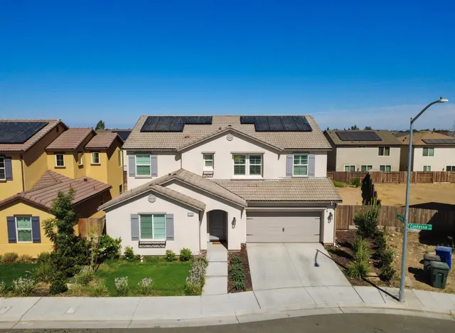 a view of a big house with a big yard and large trees