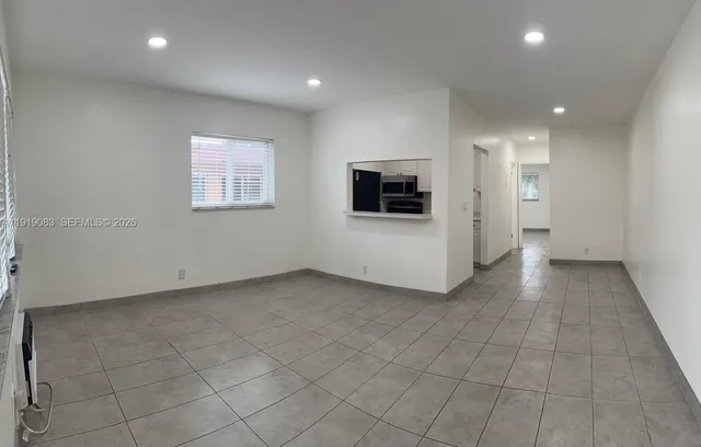 an empty room with white walls and washer