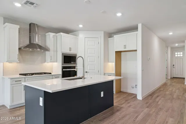 a kitchen with kitchen island white cabinets and stainless steel appliances