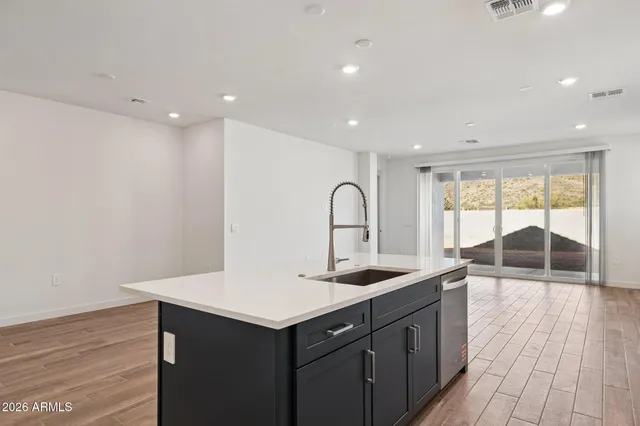 a kitchen with a sink and wooden floor