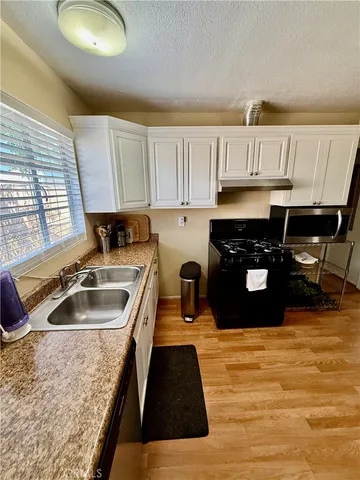a kitchen with granite countertop a stove a sink and a granite counter tops