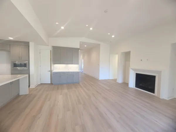 a view of empty room with wooden floor and fireplace