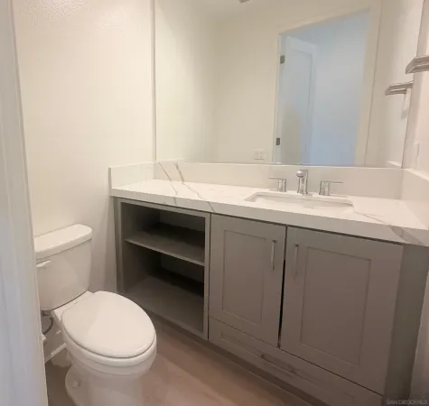a bathroom with a toilet a sink and mirror