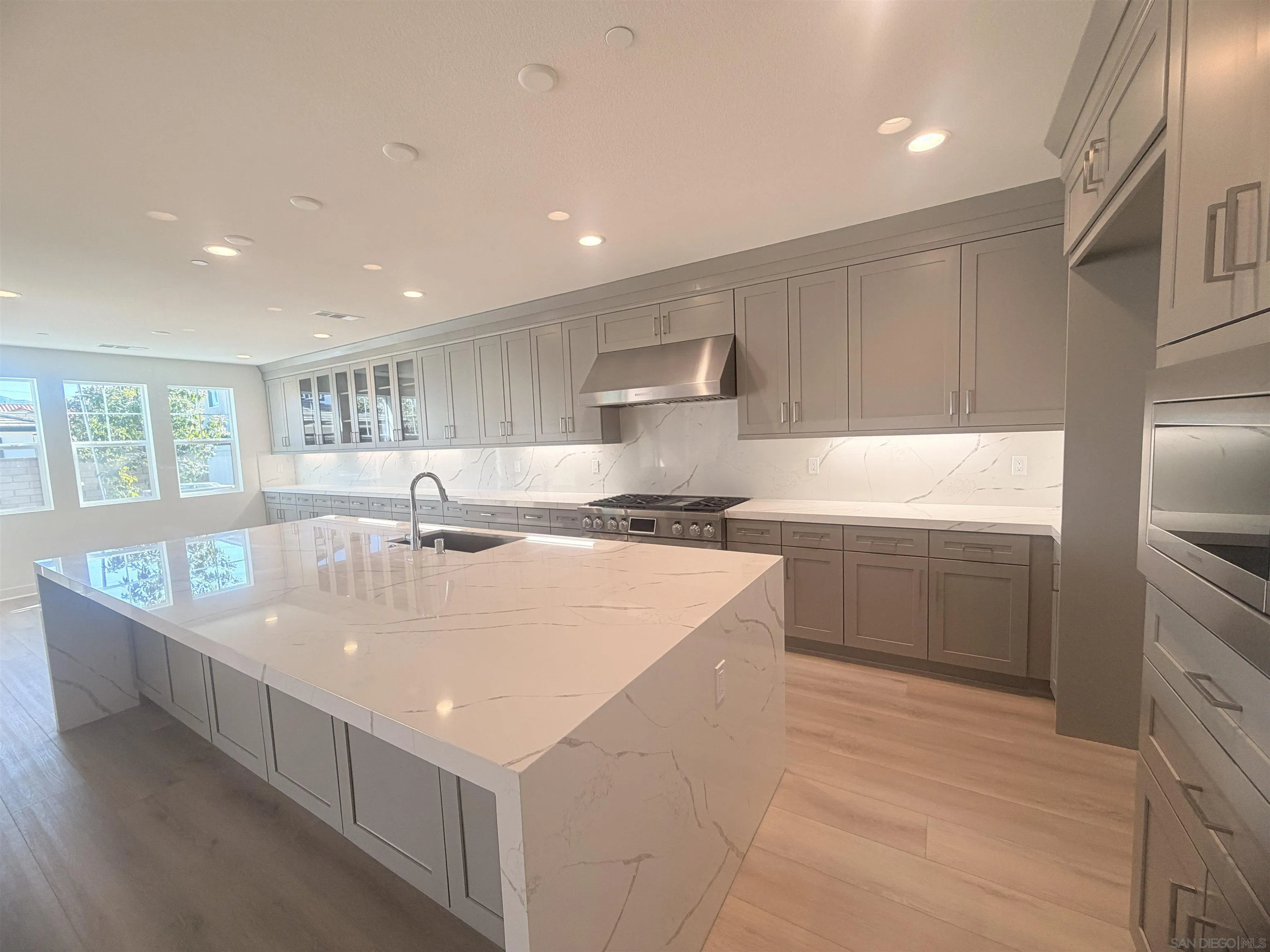 13765 Holly Oak Way Poway, CA 92064 - Photo 3 of 31 a large kitchen with kitchen island a sink a center island stainless steel appliances and a window
