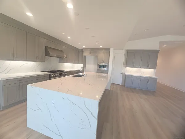 a kitchen with stainless steel appliances granite countertop a sink and a stove