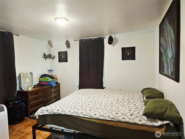 a bedroom with a bed and dresser with chair