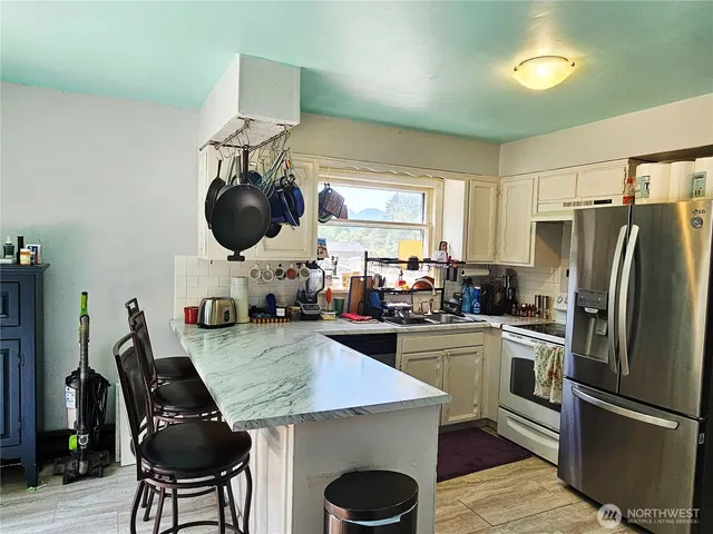 a kitchen with a table stainless steel appliances and cabinets