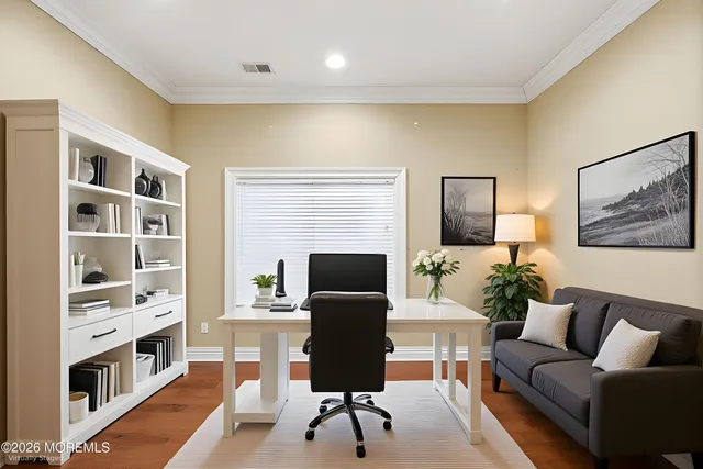 a bedroom with a bed couches and wooden floor