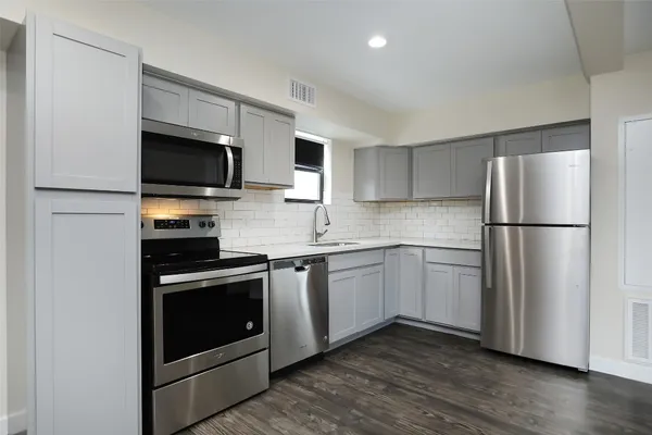 a kitchen with stainless steel appliances granite countertop a refrigerator stove a sink and a microwave