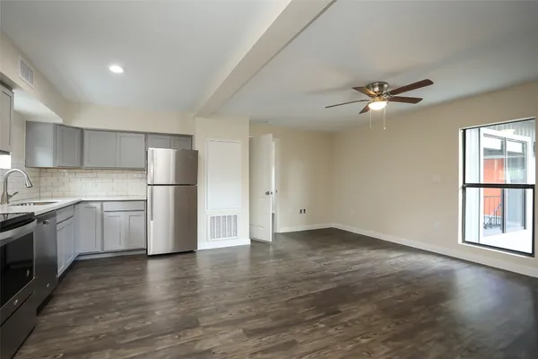 a view of a kitchen with a sink dishwasher a refrigerator and a stove top oven