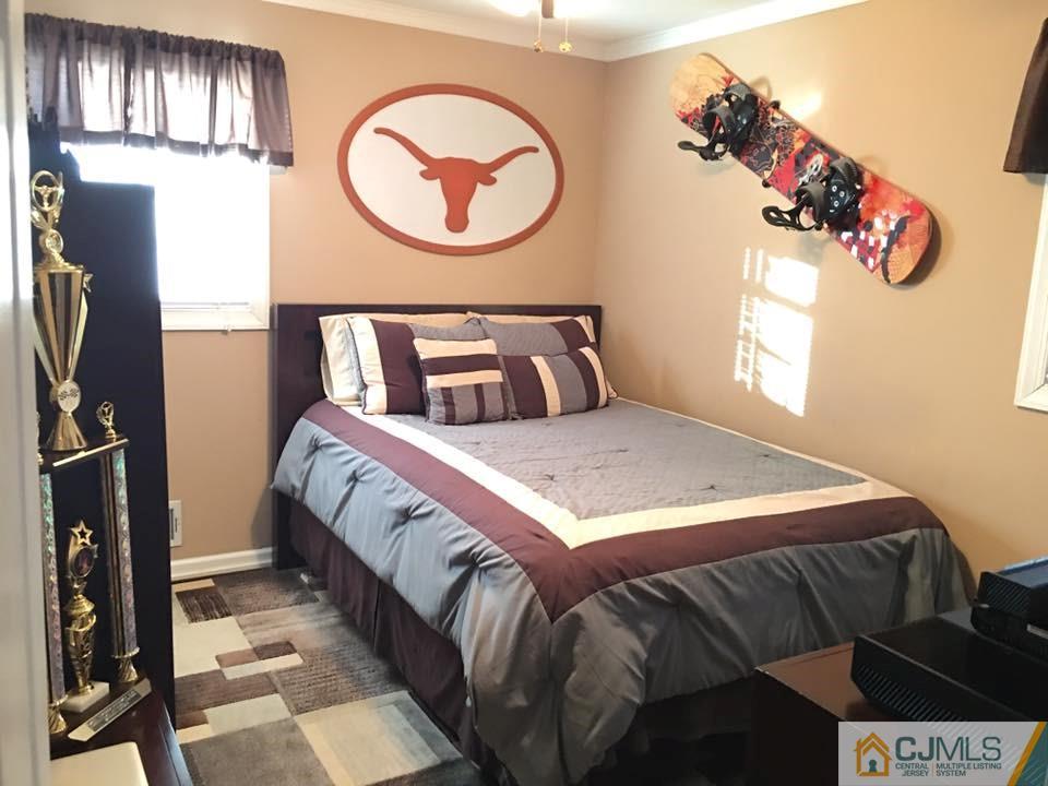 17 Wilshire Road Edison, NJ 08817 - Photo 7 of 19 a bedroom with a bed and a chandelier