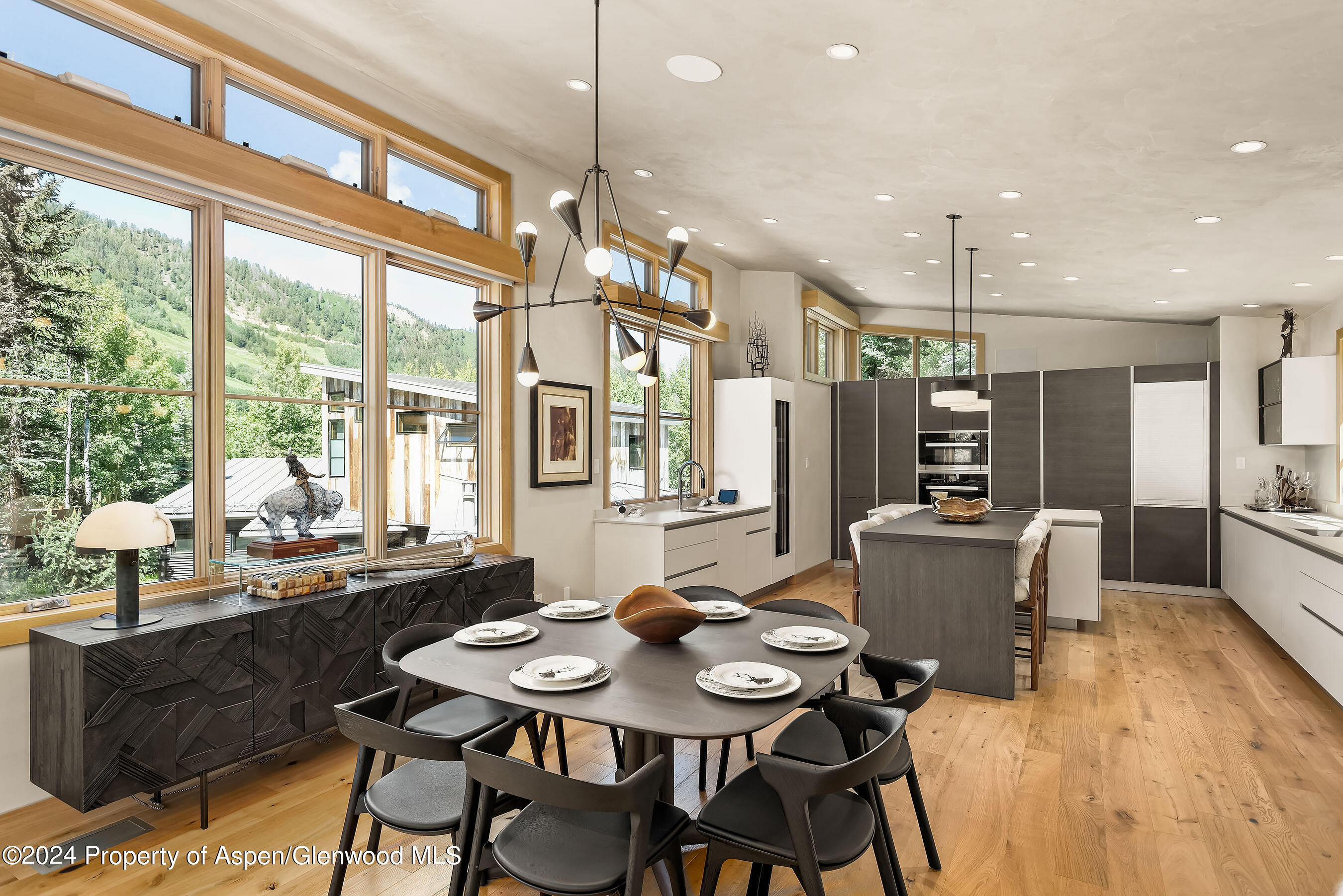 a dining room with stainless steel appliances kitchen island granite countertop a table chairs and a refrigerator