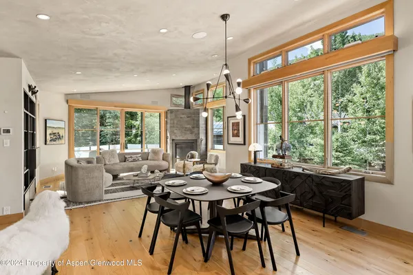 a very nice looking living room with a large window and dining table