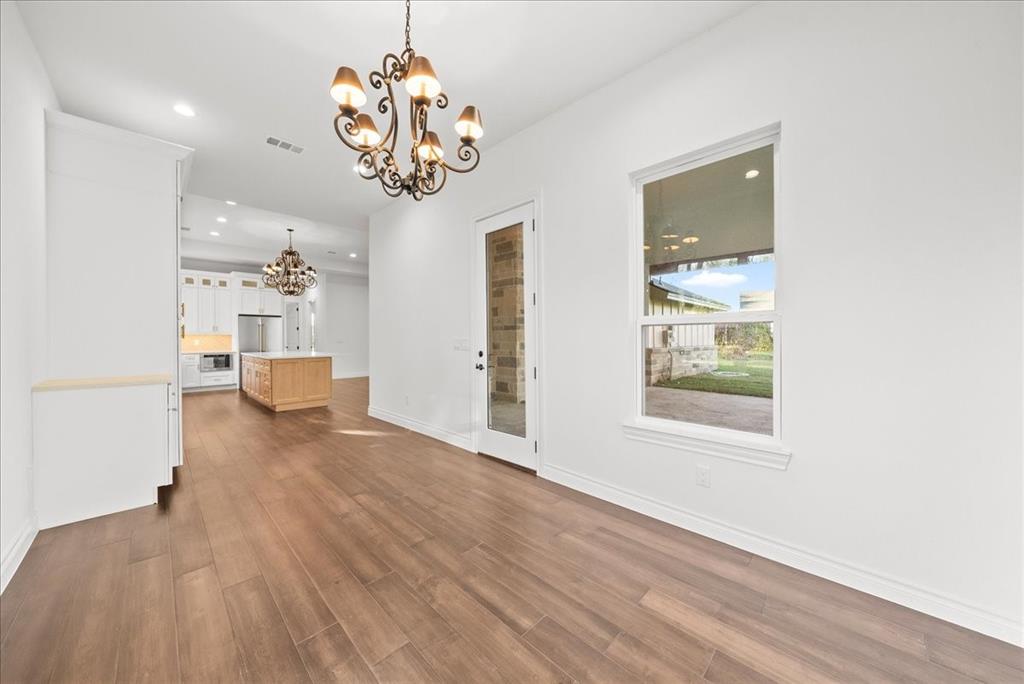 3801 Berry Hill Court Double Oak, TX 75028 - Photo 15 of 33 a view of a room with wooden floor and chandelier
