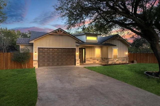 a front view of a house with a yard and lake
