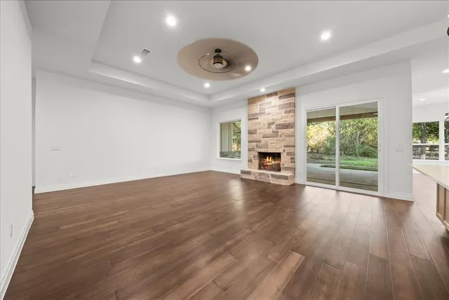 an empty room with wooden floor and fireplace