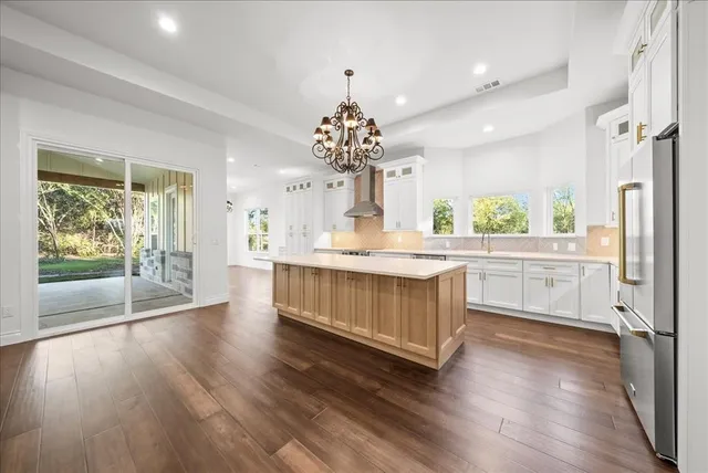 a kitchen with wooden floors and white cabinets