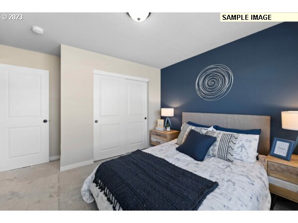 224 North 89th Loop, Unit 85 Ridgefield, WA 98642 - Photo 27 of 32 a bedroom with a bed and a lamp on dresser