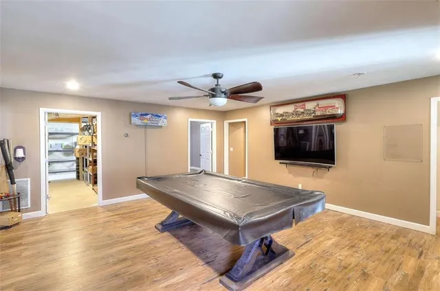 a living room with stainless steel appliances furniture and a flat screen tv