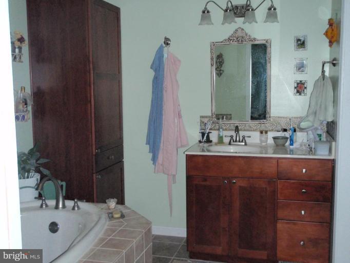 11456 Rawhide Road Lusby, MD 20657 - Photo 7 of 10 a bathroom with a sink double vanity and a mirror