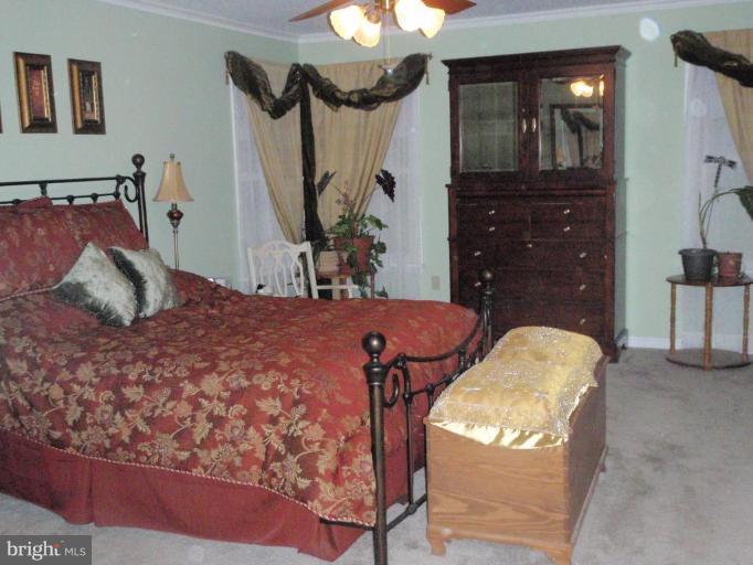 11456 Rawhide Road Lusby, MD 20657 - Photo 9 of 10 a bedroom with a bed and dresser with mirror