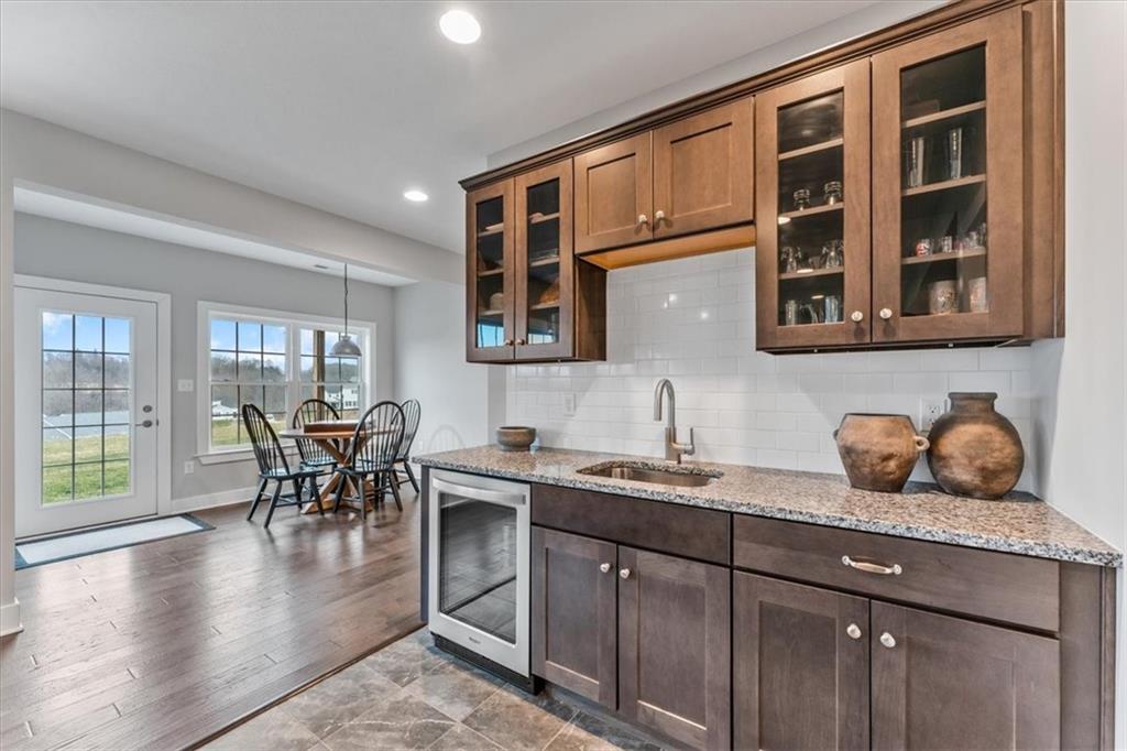 134 Pearce Road Mars, PA 16046 - Photo 21 of 25 a dining hall with stainless steel appliances granite countertop a stove a sink a dining table and chairs with wooden floor