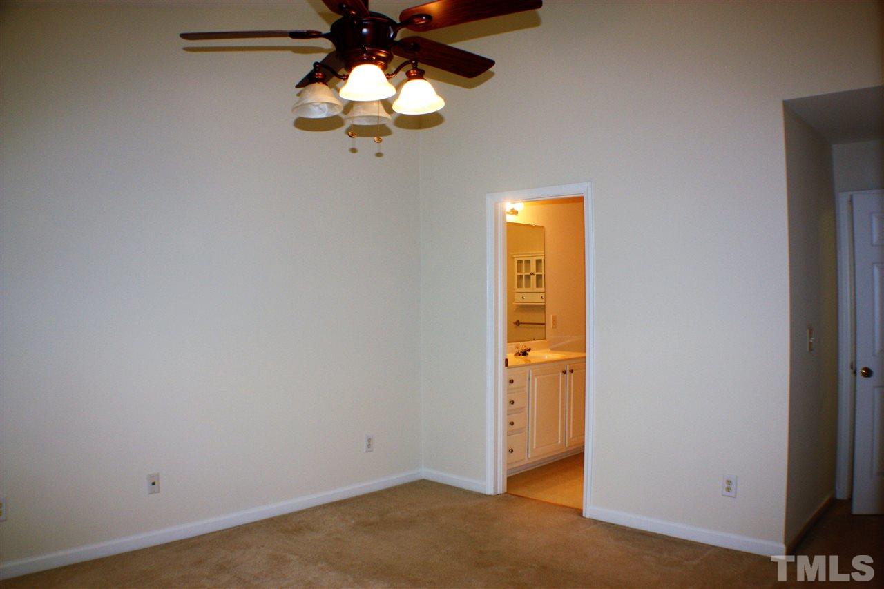 4750 Black Mountain Path Raleigh, NC 27612 - Photo 18 of 30 an empty room with a chandelier fan and windows