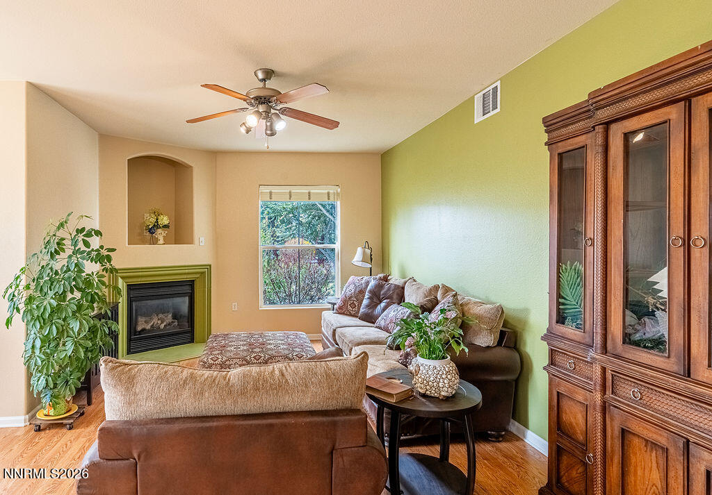 9050 Double R Boulevard, Unit 212 Reno, NV 89521 - Photo 2 of 33 a living room with furniture a fireplace and a potted plant