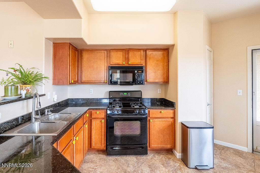9050 Double R Boulevard, Unit 212 Reno, NV 89521 - Photo 6 of 33 a kitchen with a stove a sink and a microwave