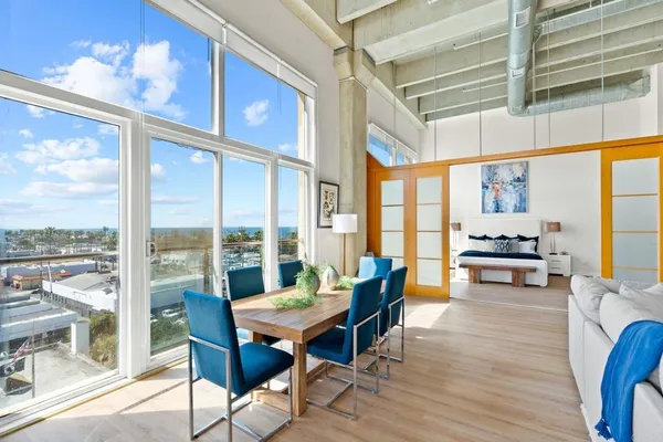 a view of a dining room with furniture large windows and wooden floor