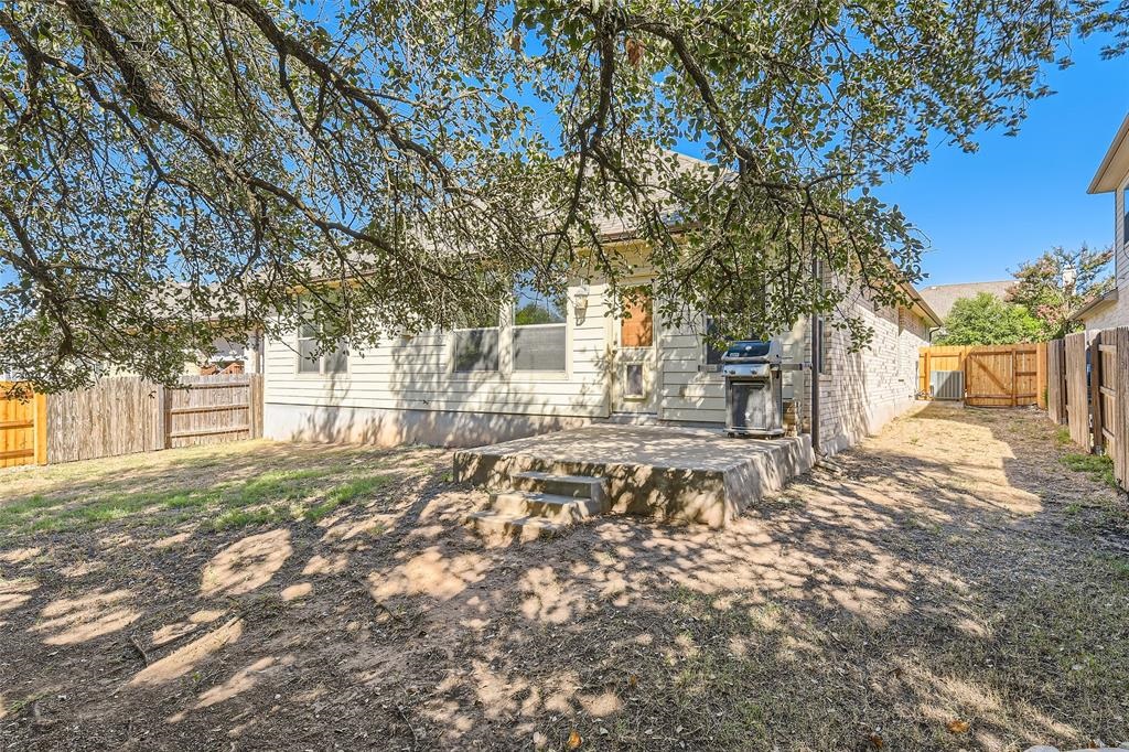 290 Maeves Way Austin, TX 78737 - Photo 2 of 13 A spacious backyard with mature trees provides ample shade for outdoor enjoyment.