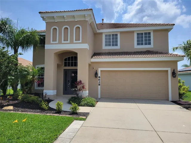 a front view of a house with a garden and garage