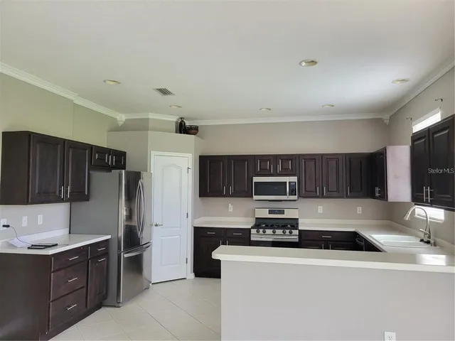 a kitchen with stainless steel appliances granite countertop a refrigerator stove a sink and dishwasher