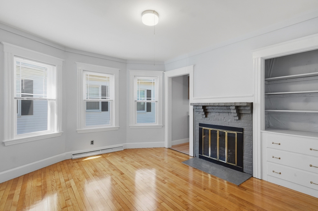55 Addison Avenue Lynn, MA 01902 - Photo 5 of 23 a view of an empty room with a fireplace and a window