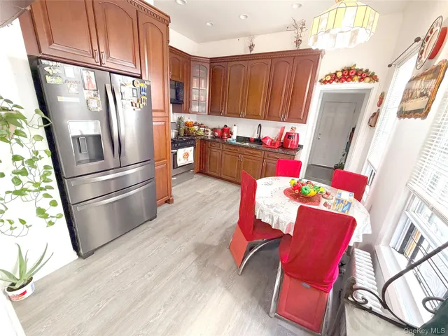 a kitchen with stainless steel appliances kitchen island granite countertop a refrigerator stove and wooden floor