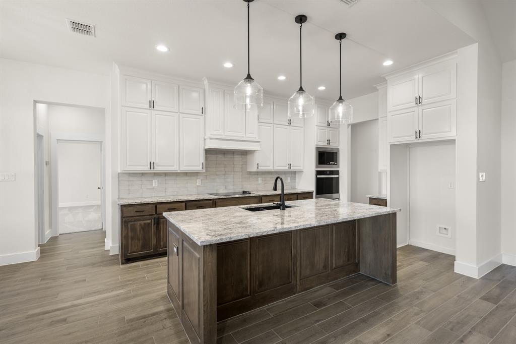4867 Prairie Sky Lane DISH, TX 76247 - Photo 11 of 27 a large kitchen with granite countertop a stove a sink a center island and wooden floor