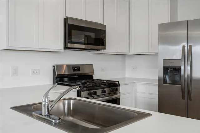 a kitchen with stainless steel appliances a refrigerator stove and microwave