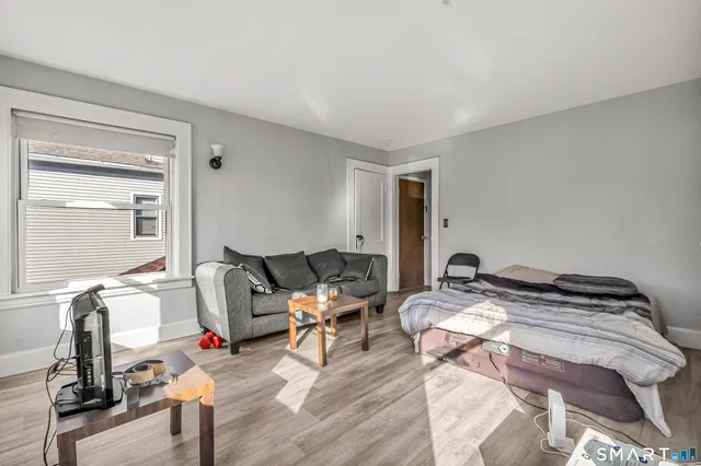 a bedroom with a bed and wooden floor