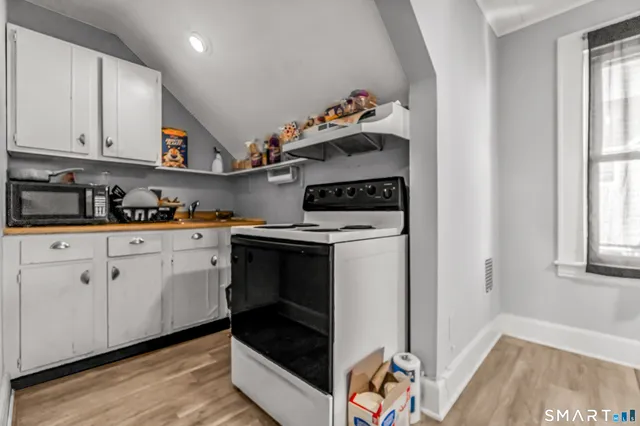 a kitchen with stainless steel appliances a stove and white cabinets