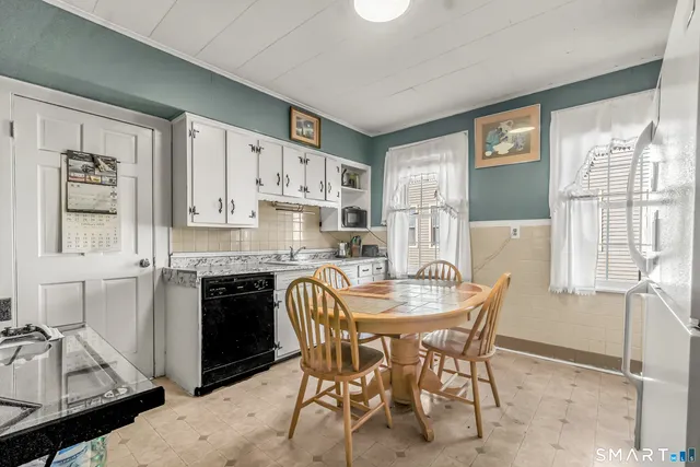 a kitchen with stainless steel appliances granite countertop a stove a refrigerator a sink dishwasher with a dining table and chairs